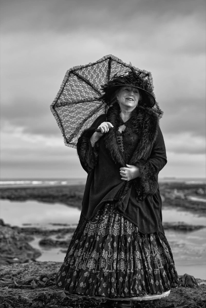Woman with a parasol on the rocks